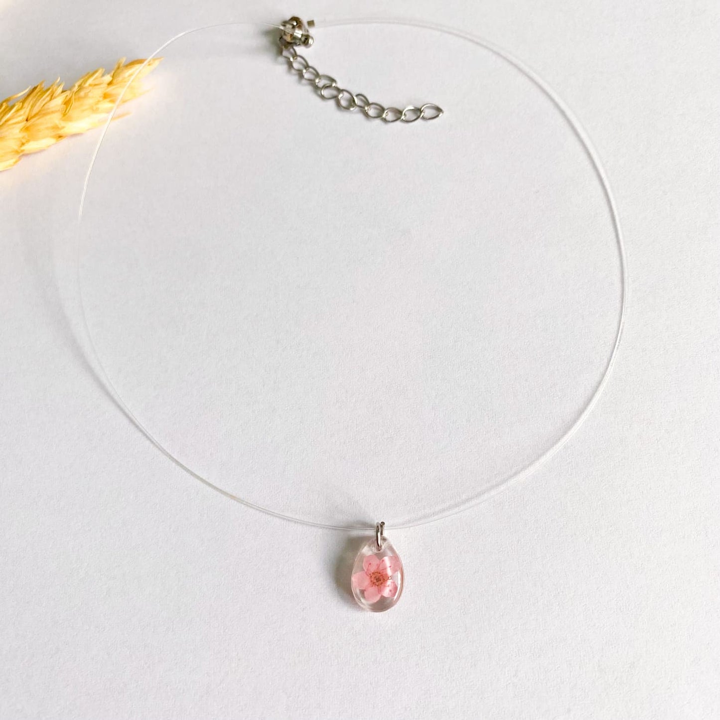 Lănțișor pe fir transparent cu floare roz oval