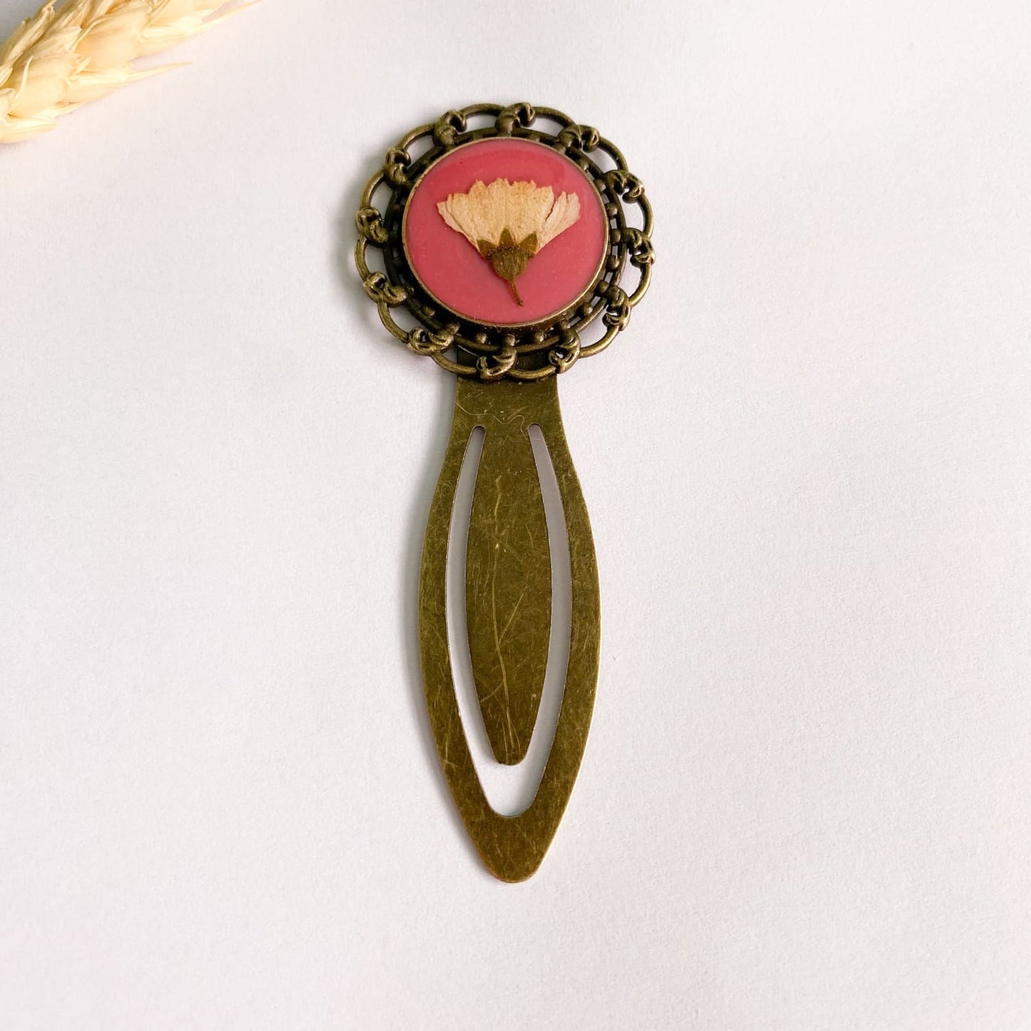 Semn de carte cu floare albă și fundal roz