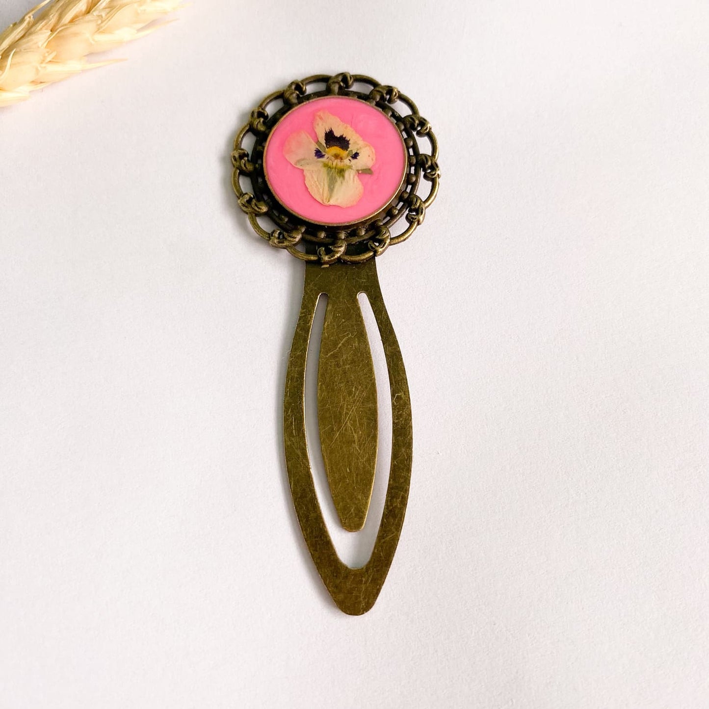 Semn de carte cu floare albă și fundal roz neon