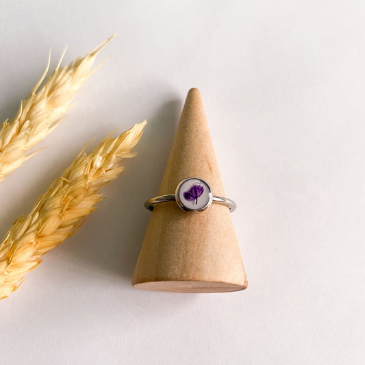 Inel cu floare mov închis și fundal alb