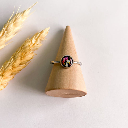 Inel cu flori multicolore și fundal negru