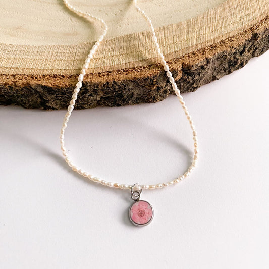 Colier cu perle de cultură, fundal alb și floare roz