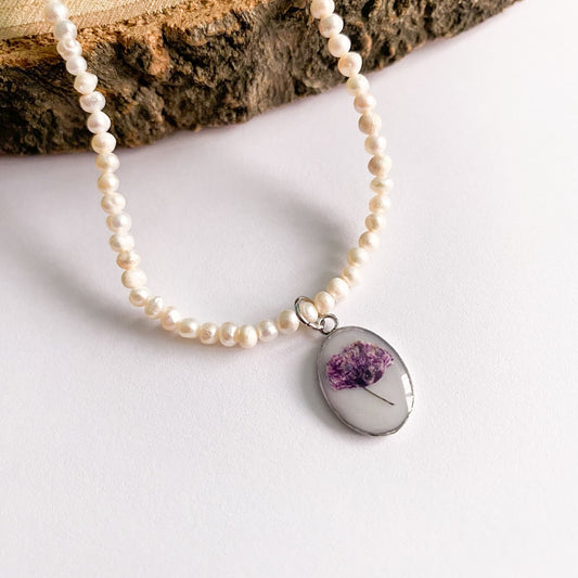 Colier cu perle de cultură, fundal alb și floare mov