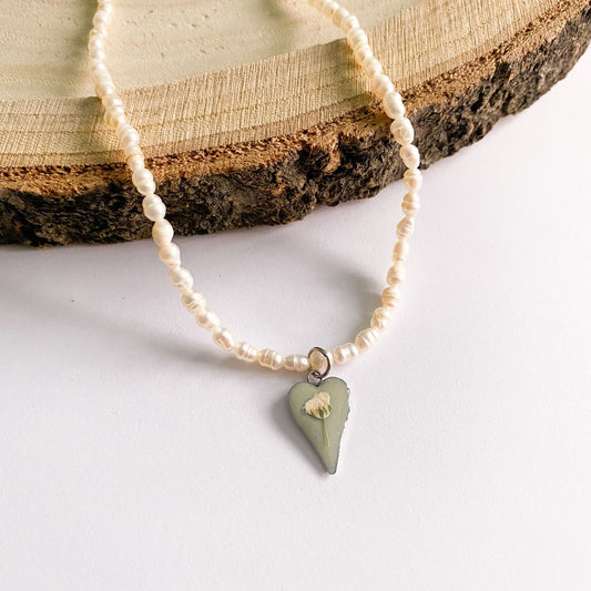 Colier cu perle de cultură, fundal verde și floare albă