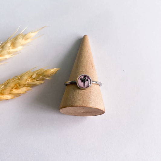 Inel cu floare neagră și fundal roz