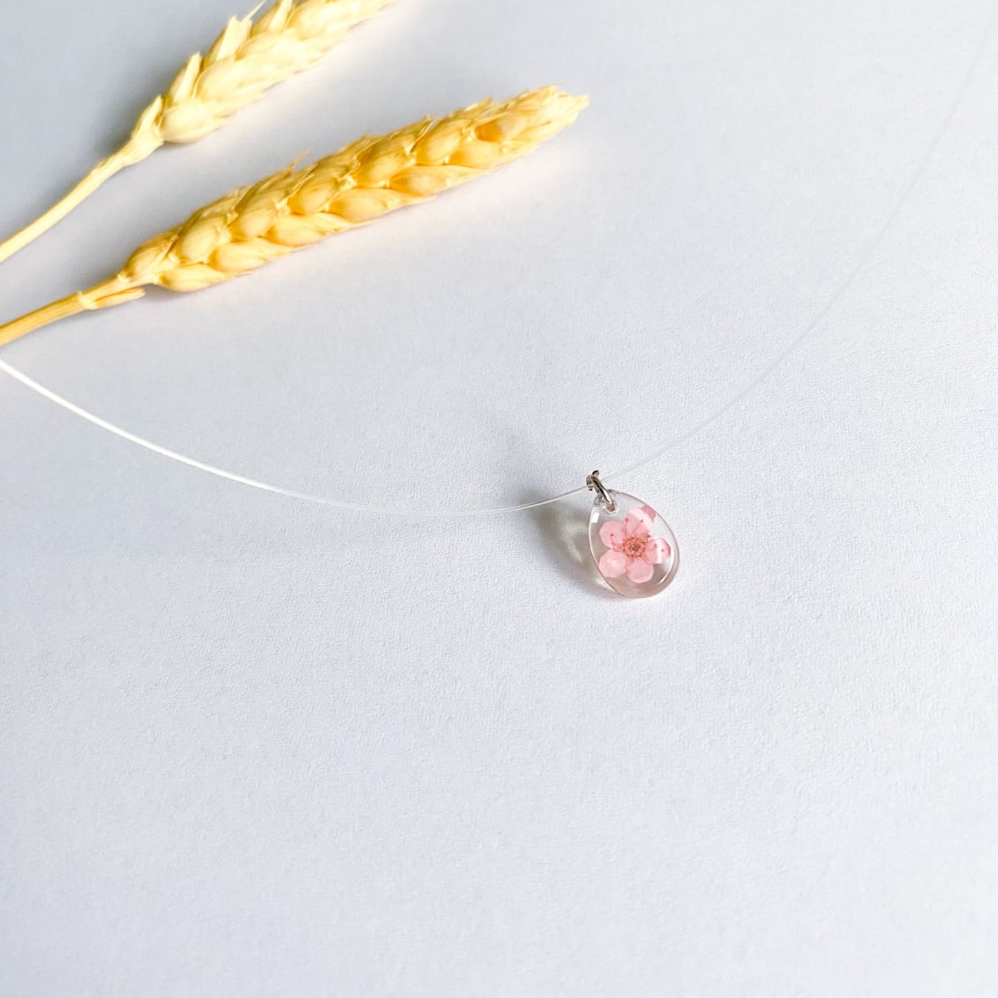 Lănțișor pe fir transparent cu floare roz oval