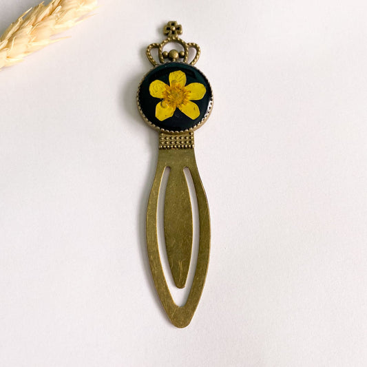 Semn de carte cu floare galbenă și fundal negru